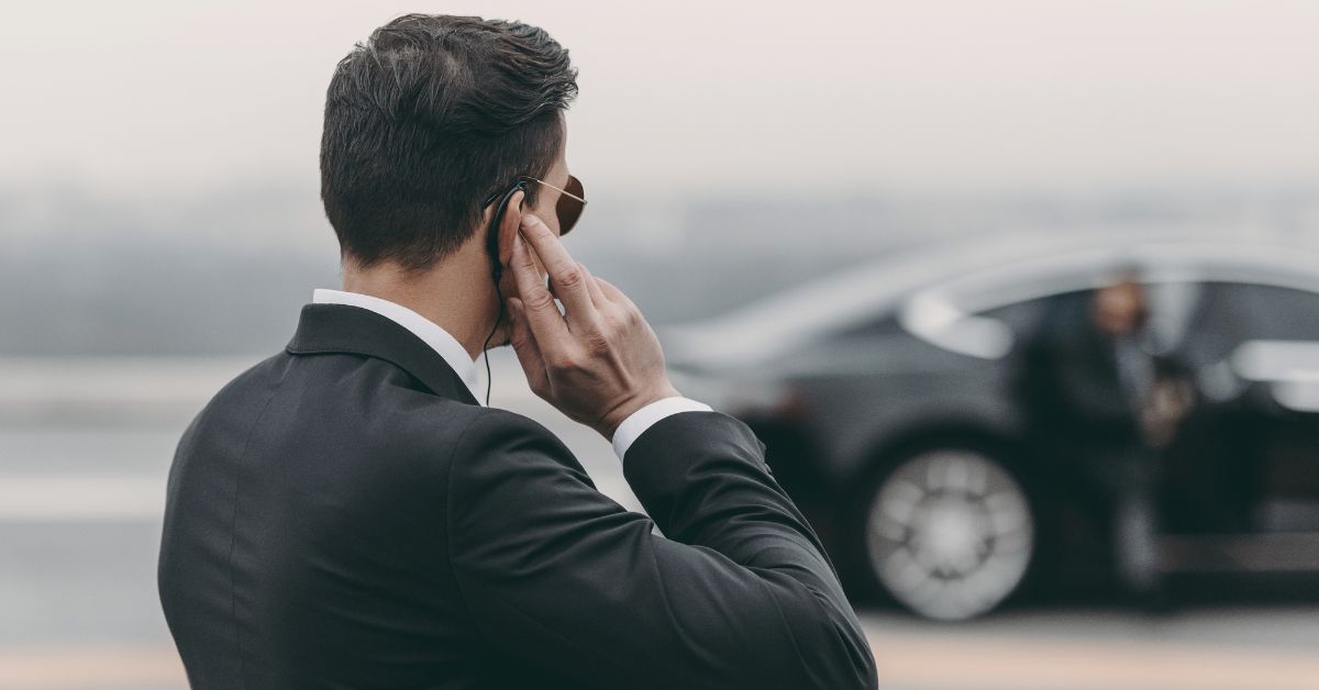 security officer with ear piece looking at car